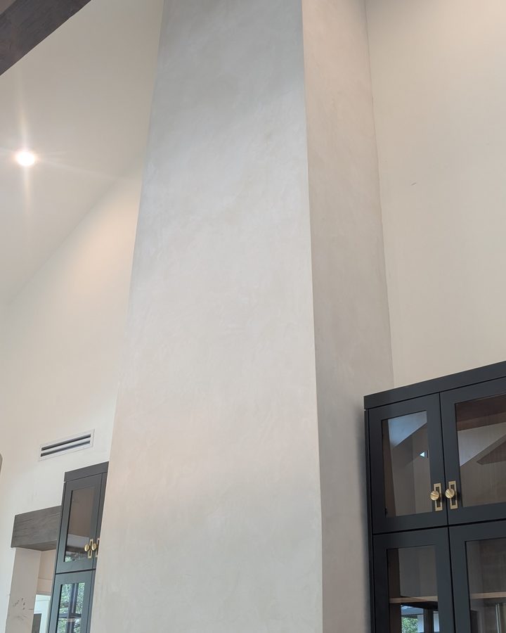 A tall pale range hood in a modern kitchen.