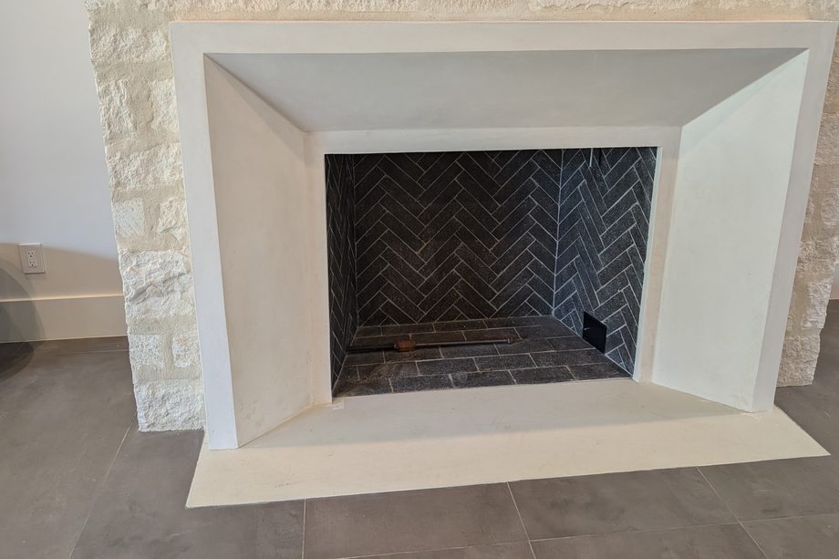 A modern white fireplace surround with a wide hearth.