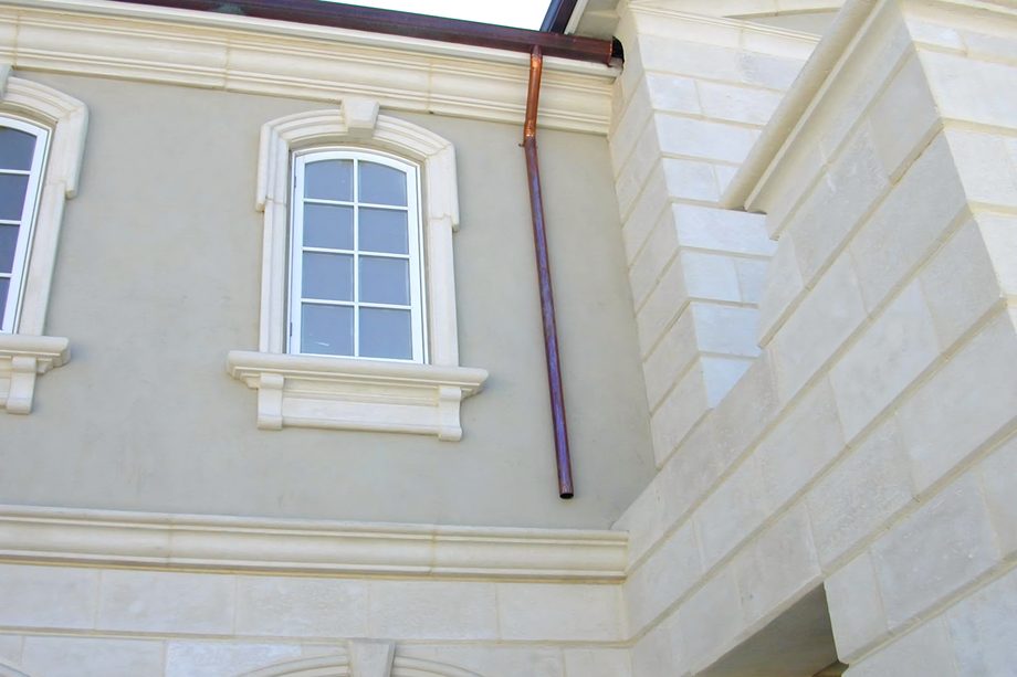 Window surrounds, bands and quoins in pale coated stone.