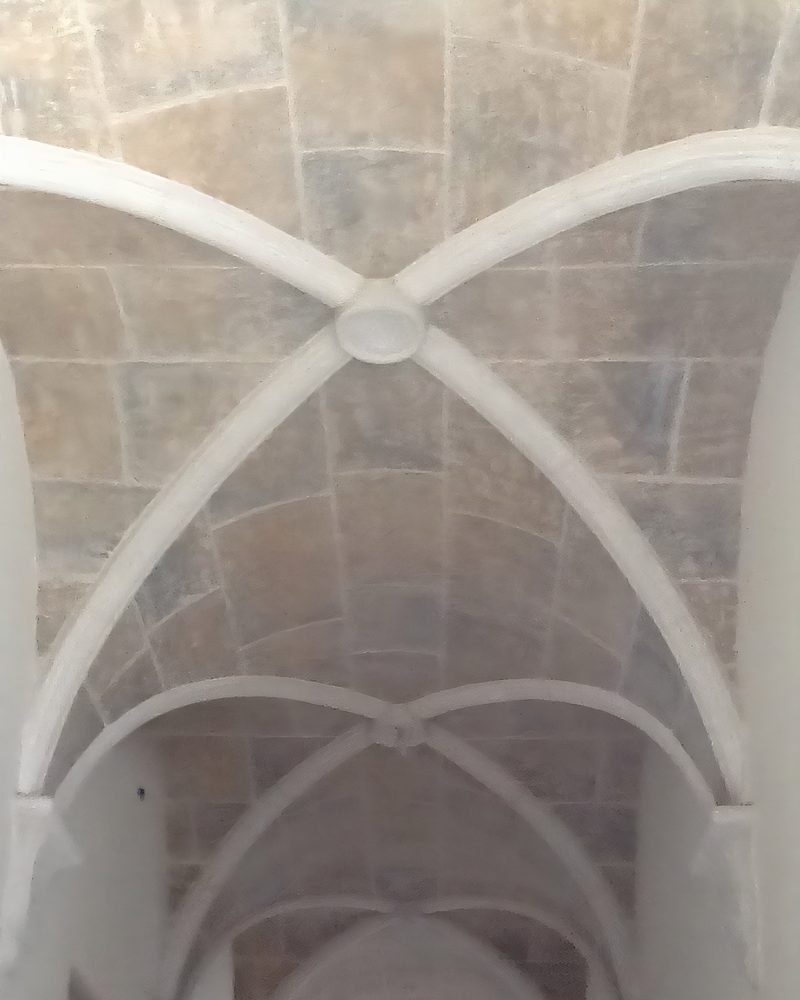 A ribbed vaulted ceiling in coated stone.