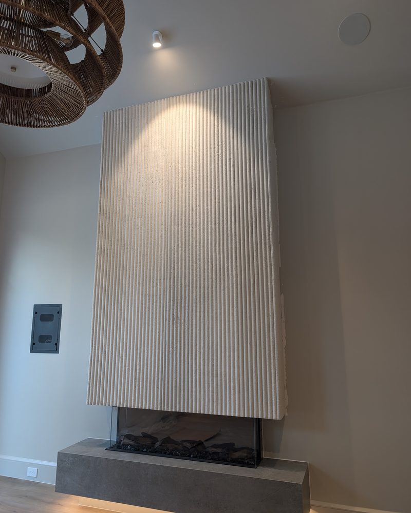 A fluted modern fireplace surround above a low hearth.
