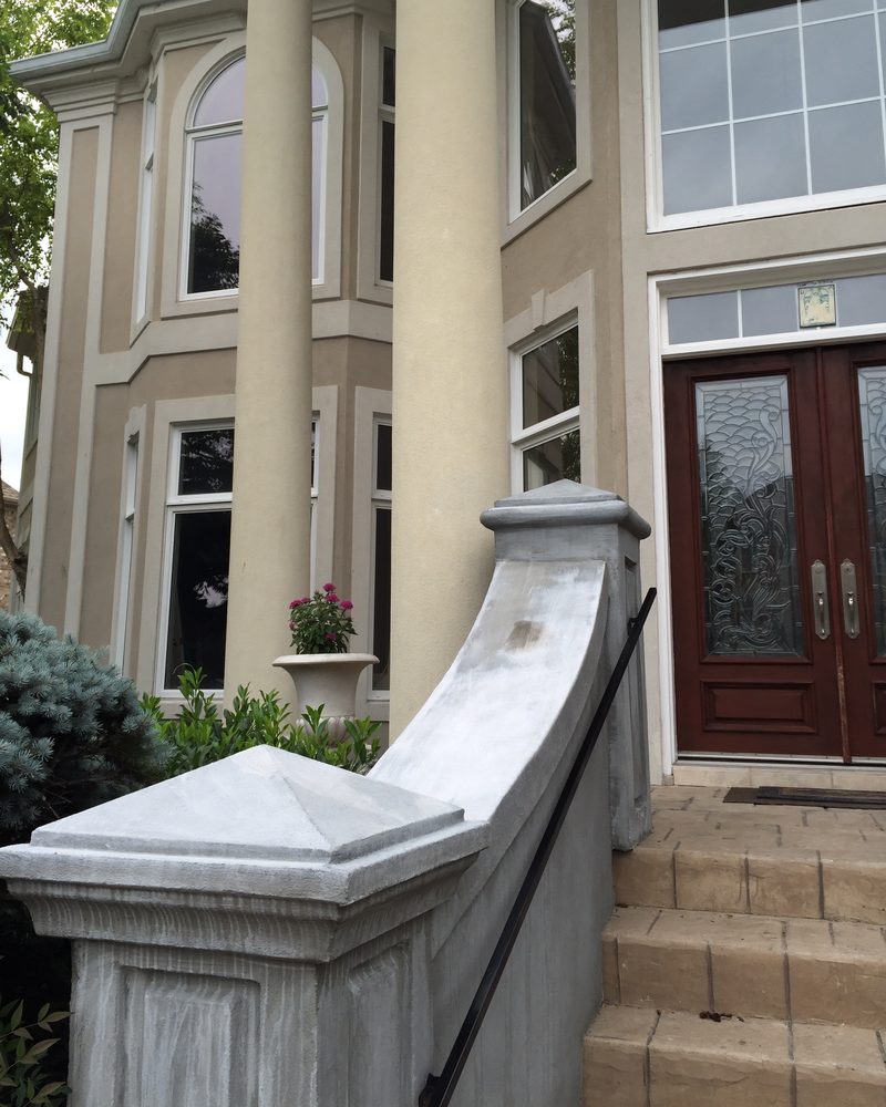 Entrance steps with a coated pier cap and curved wall.