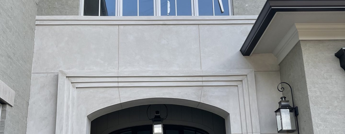 An arched entry surround in smooth Marblecoat.
