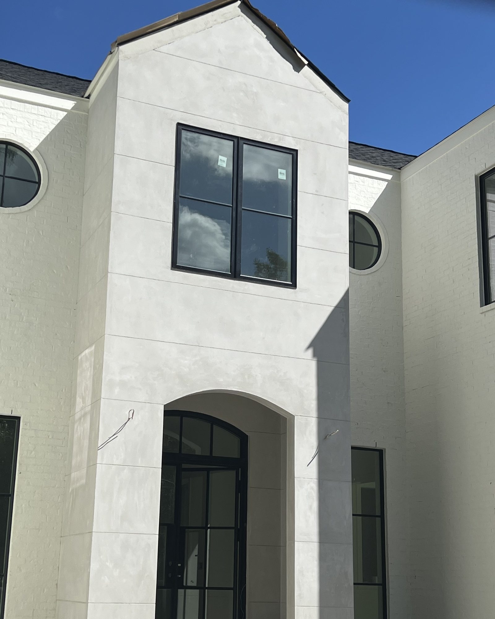A modern white facade in smooth Marblecoat with an arched entry.