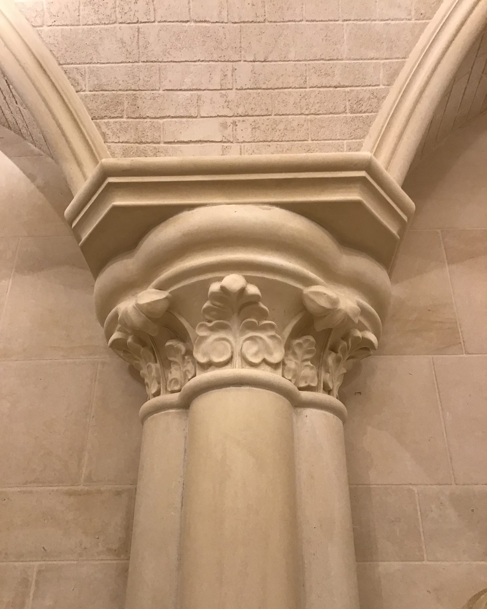 A carved column capital and cut-block walls in Stonecoat.