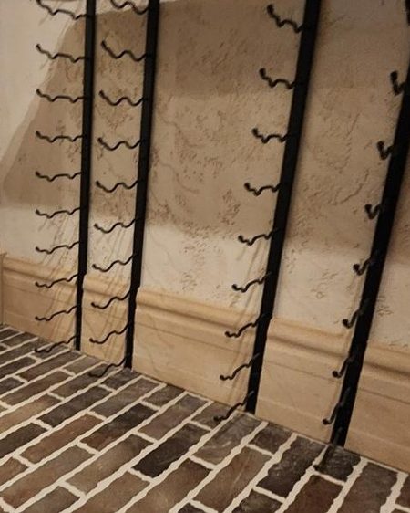 Cut-stone walls in Stonecoat behind a wine rack.