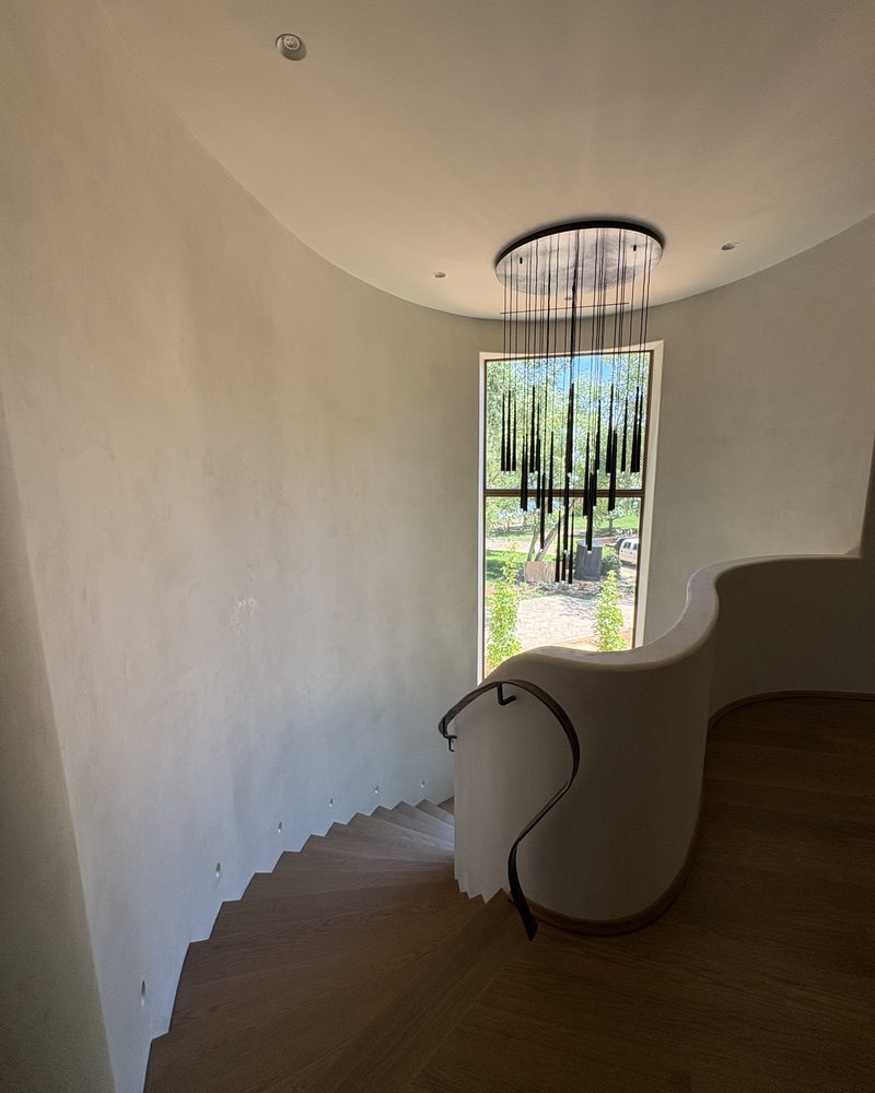A curved wall in Lime Plaster Fine beside a tall window.