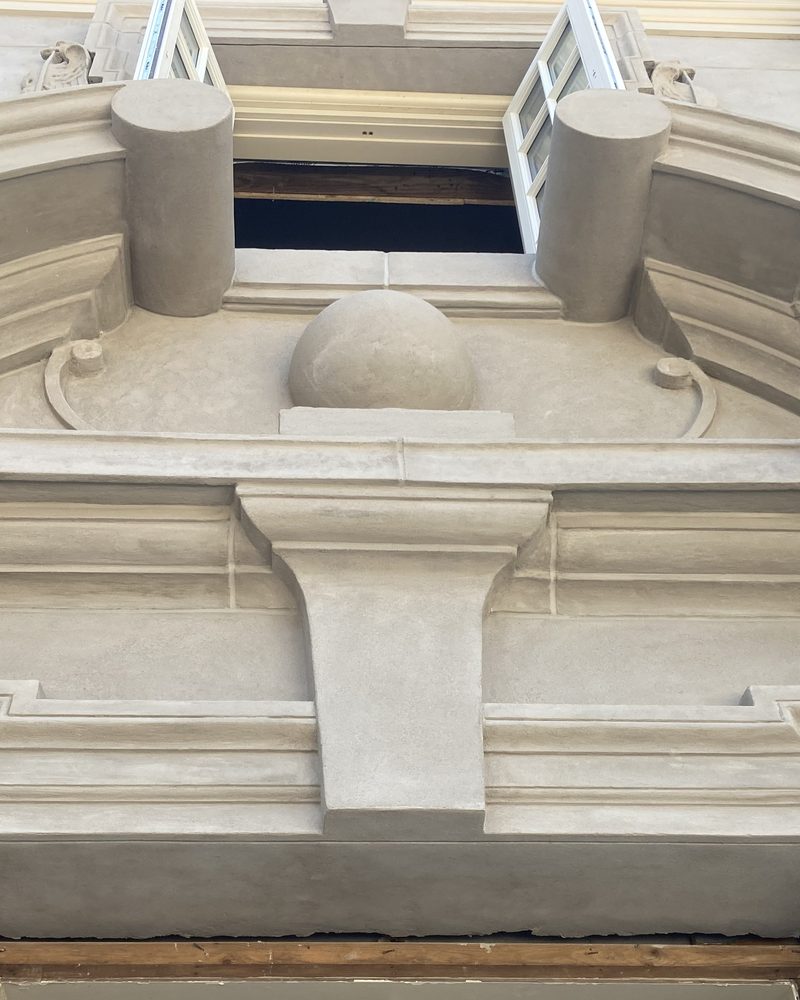 A carved pediment and scroll brackets in Arcus Plaster.