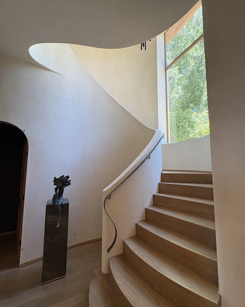 A curved staircase finished in Lime Plaster Fine.