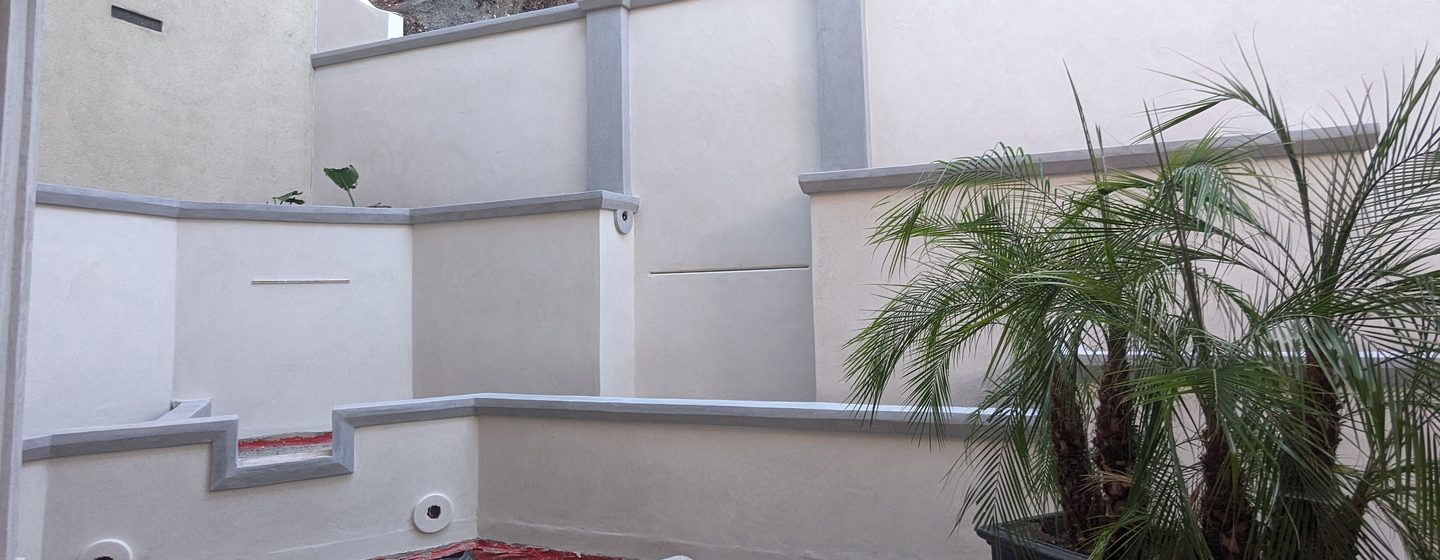 Modern courtyard walls in white coating with grey bands.