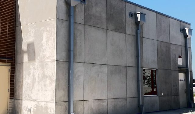 A modern grey commercial building in coated stone.