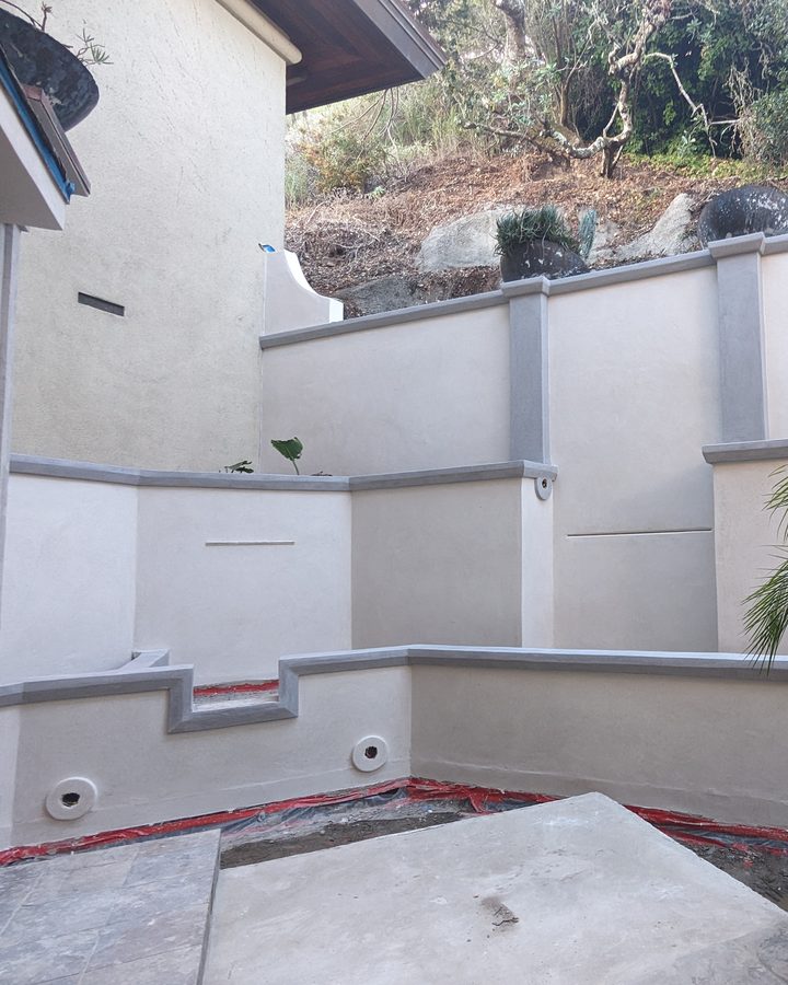 Modern courtyard walls in white coating with grey bands.