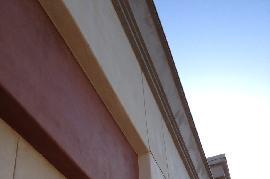 A commercial facade in cream with terracotta bands.